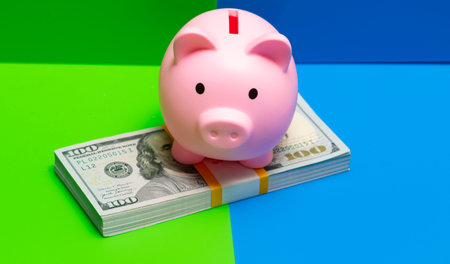 Saving money in piggy bank for personal finance. Saving capital in bank for business planning. Saving income in bundle for growth strategy. Saving cash in reserve for emergency fund.の写真素材