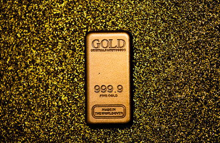 Gold bullion on shiny background for trading. Gold asset in luxury texture. Gold savings for financial growth. Gold sparkle on metallic bokeh.の写真素材