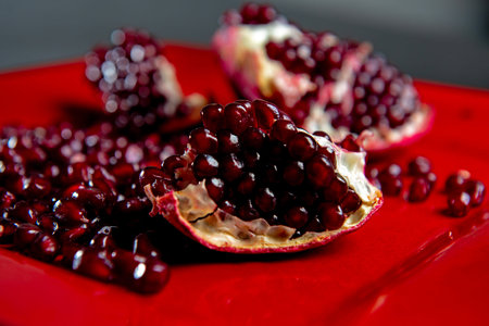 Pomegranate arils and halves. Pomegranate seeds. Pomegranate fruit.
