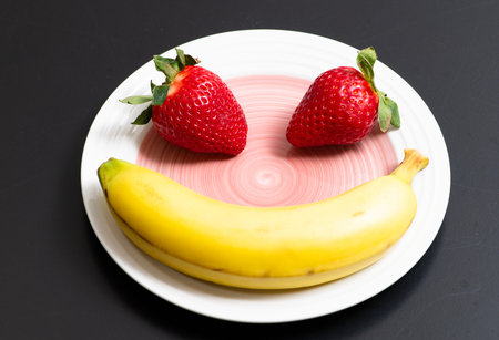 Banana strawberry background concept. Bananas with strawberries. Fresh ripe bananas and strawberries. Summer banana fruit.の写真素材