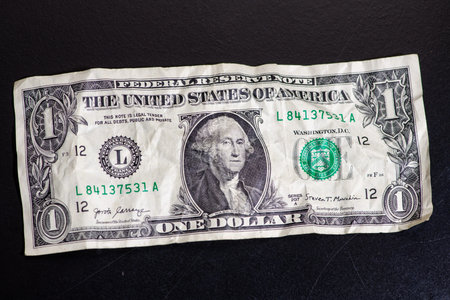 Crushed and Wrinkled One Dollar Bill. Crumpled one dollar bill close up for US cash concept. Wrinkled US dollar banknote money texture. Used American one dollar note with George Washington portrait.の写真素材