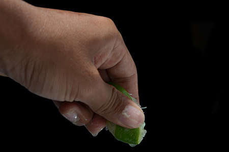 Hand of a squeezing a green limeの写真素材