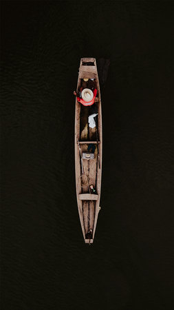 Aerial view of a small wooden boat on the water. View from above.