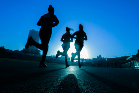 Marathon running race, people silhouettes on city road at sunset