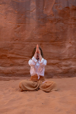 Woman meditating in Wadi Rum desert in Jordan, Middle Eastの写真素材