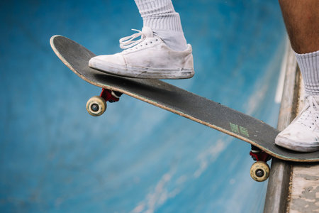 skateboarder legs riding skateboard at skatepark, extreme sport