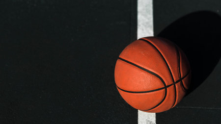 Basketball ball on the court with a white line in the background