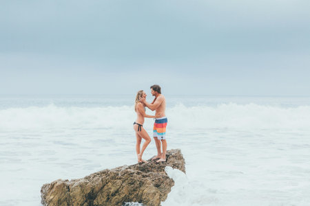 Couple in love kissing and hugging on the rocks at the beach.の写真素材