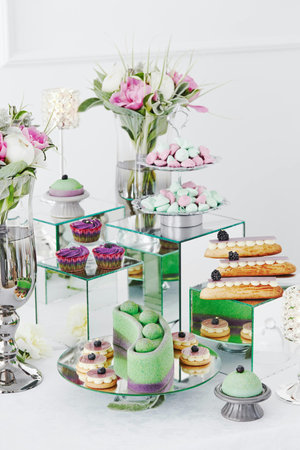 catering wedding buffet with cupcakes, macaroons and flowersの写真素材