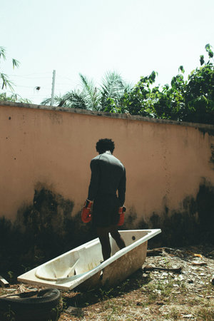 Rear view of a man standing in a bathtub