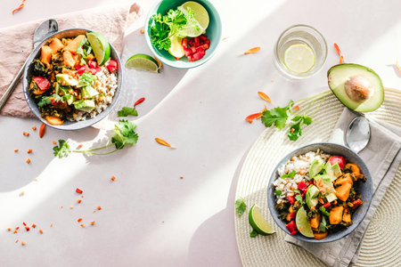 Top view of a bowl of spicy quinoa salad with avocado, pomegranate seeds, lime and parsley.