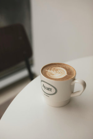 Coffee cup on white table in coffee shop, stock photoの写真素材