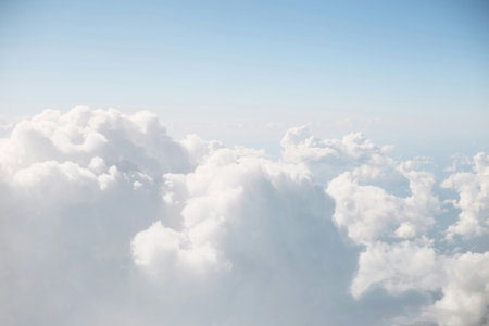 Cloudscape, view of blue sky and white clouds from airplane window