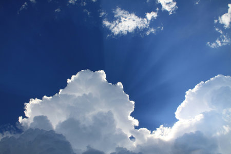 Blue sky with clouds and sunbeams, closeup of photo