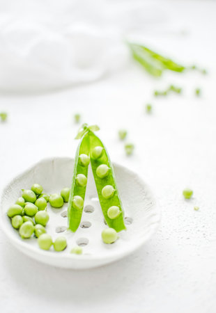 Fresh green peas on a white background. Selective focus. Copy space.