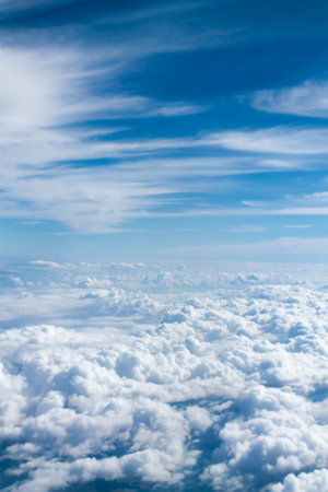 clouds in the blue sky as seen through window of an aircraft