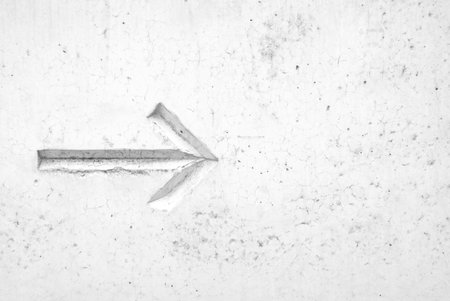 White arrow on the wall in black and white tone for background.