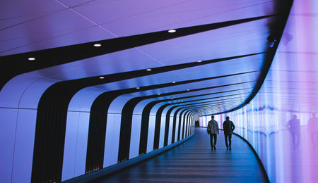 pedestrian walkway in modern office building interior with neon lights