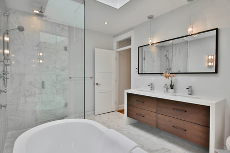 Interior of modern bathroom with white walls, comfortable bathtub and mirror