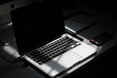 Laptop computer with black screen on the table in the dark.
