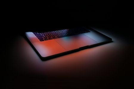 Laptop on black background with red and blue light. 3d renderingの写真素材