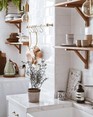Interior of modern kitchen with white tiled walls and wooden shelves