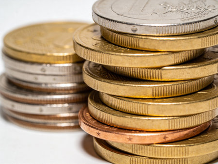 Euro coins stacked on each other in different positions. Shallow depth of field