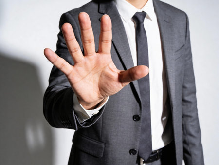 Businessman showing stop sign with his hand. Focus on hand.の写真素材