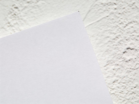 Blank white paper on white cement wall texture background with copy space.の写真素材