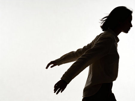 Silhouette of a young woman dancing on a white background.の写真素材