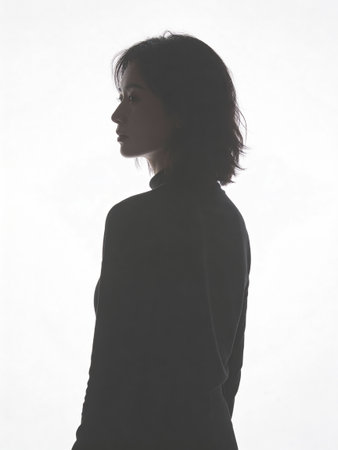 silhouette of a woman in a black sweater on a white backgroundの写真素材