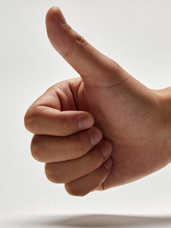 Hand showing thumbs up sign on a white background, close-up