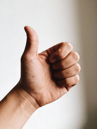 thumbs up on a white background, symbol photo for success or achievementの写真素材