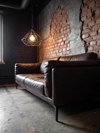 interior of loft style room with black leather sofa and brick wallの写真素材