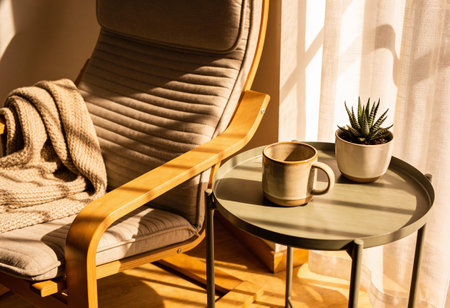 Cozy armchair and coffee cup in living room with sunlight.