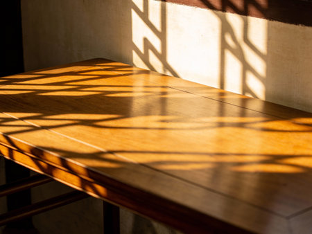 Wooden table and shadow of window in the morning, stock photoの写真素材