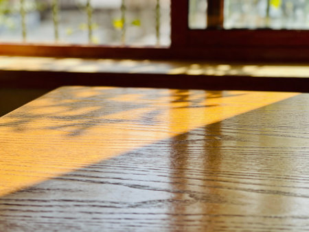Wooden table in coffee shop with sunbeam and bokehの写真素材