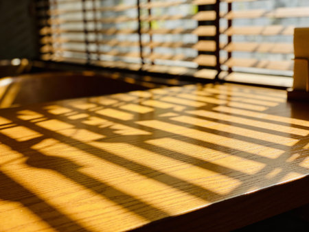 Wooden table in coffee shop with sunlight and shadow from window.の写真素材