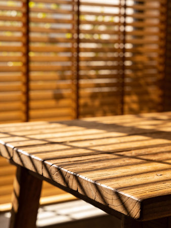 Wooden table and blinds in the morning light. Selective focus.