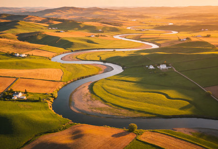 Aerial view of the river flowing through the fields at sunset.の写真素材