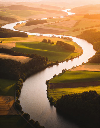 Aerial view of the river and green fields at sunset in Polandの写真素材