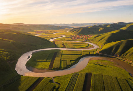 Aerial view of a river winding through rural landscape at sunsetの写真素材