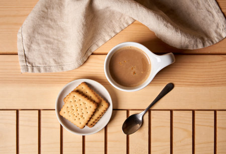 Cup of coffee with crackers on wooden table, top viewの写真素材