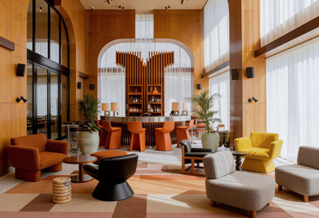 Interior of a hotel lobby with orange armchairs and coffee tables