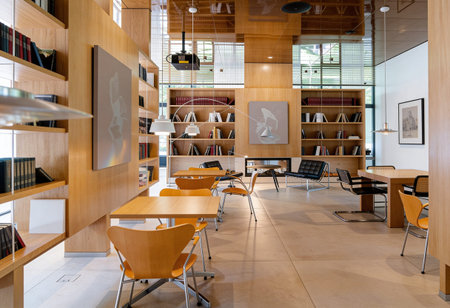 Interior of a modern library with orange chairs and bookshelves