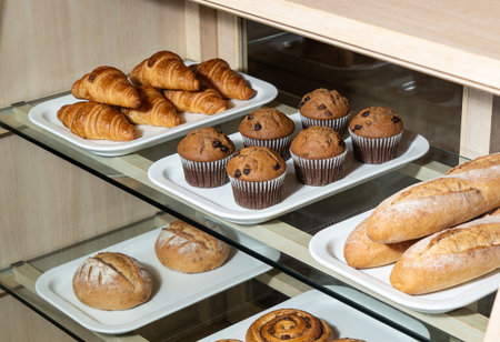 Chocolate muffins with raisins on a shelf in a bakery