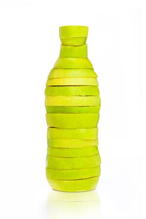 Bottle made from green sliced apples on whiteの写真素材