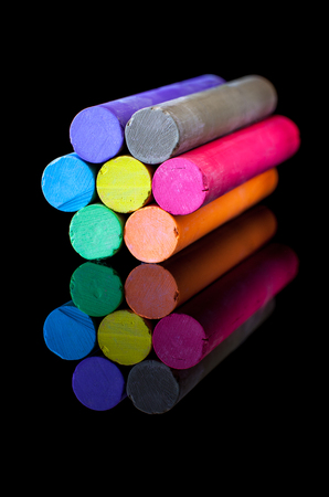 Flower-shaped colored chalk in variety of colors on a black backgroundの写真素材