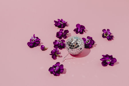 Silver ball with purple flowers on pink background. minimal concept.の写真素材