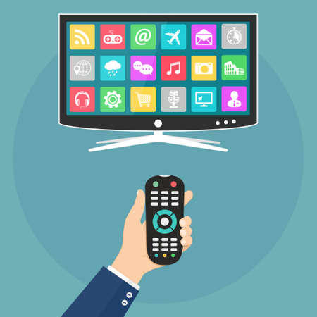 Hand holding remote control and smart tv with apps icons on screen